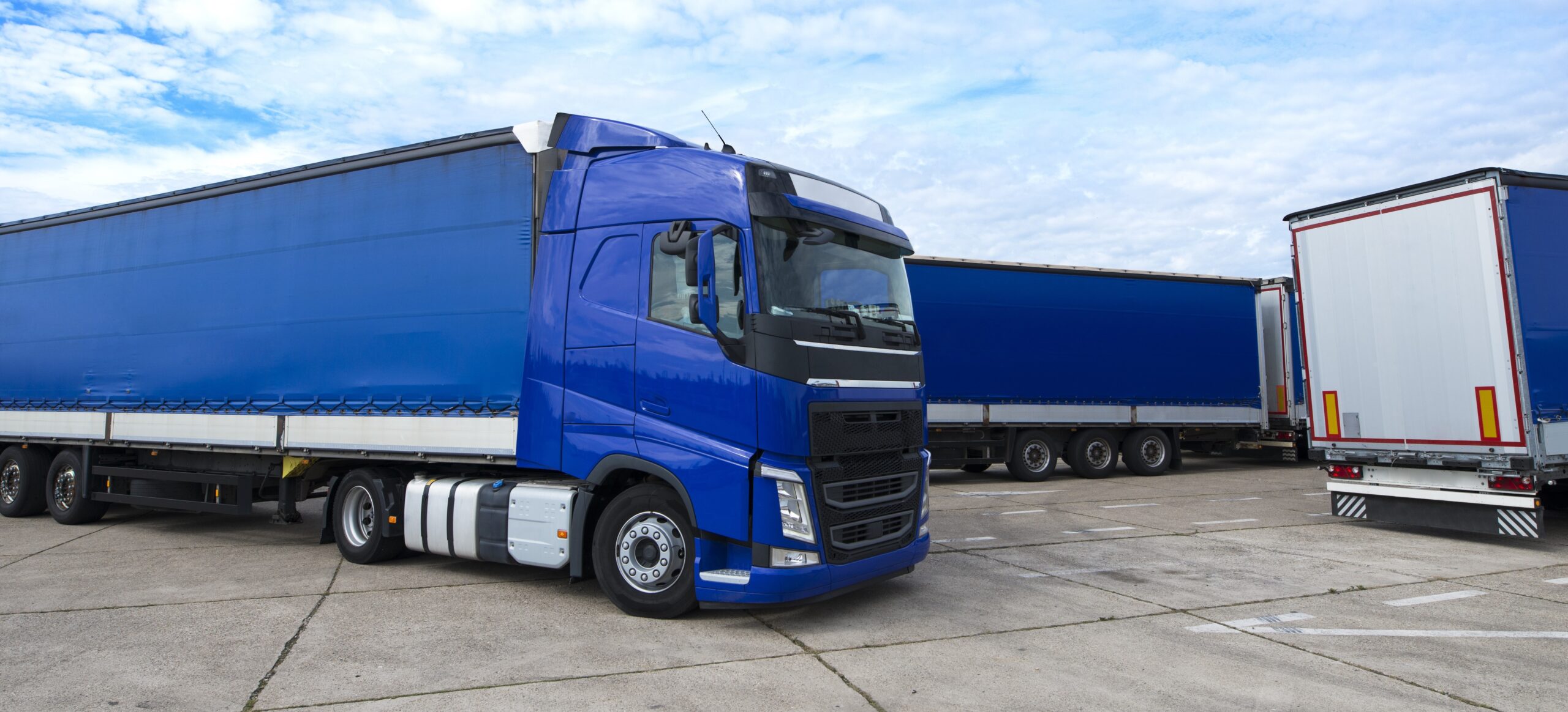 Truck vehicle with trailers in background.
